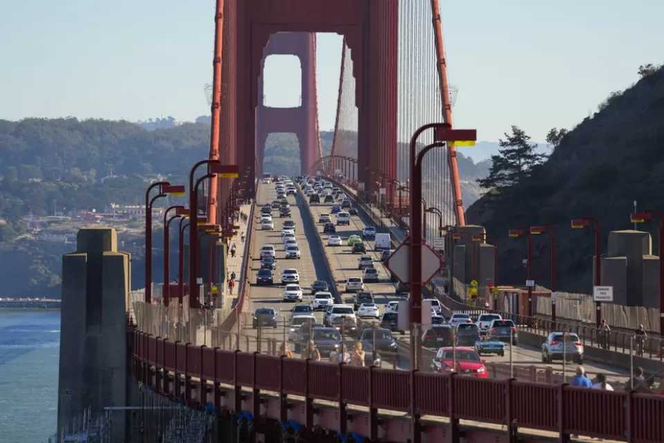 The Golden Gate bridge viewed from Marin, with cars passing in either direction on a sunny day.